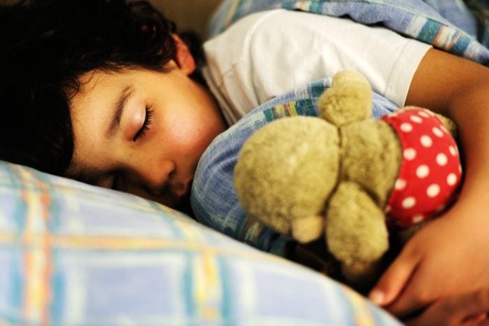 Boy sleeping with stuffed animal