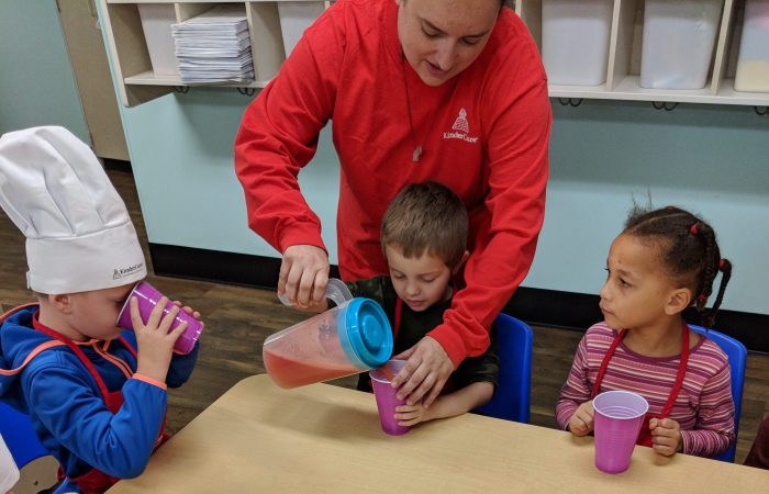 teacher pouring juice for kids