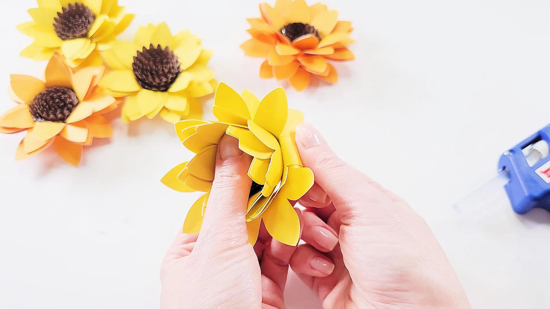 folding petals back on a nearly complete sunflower paper flower